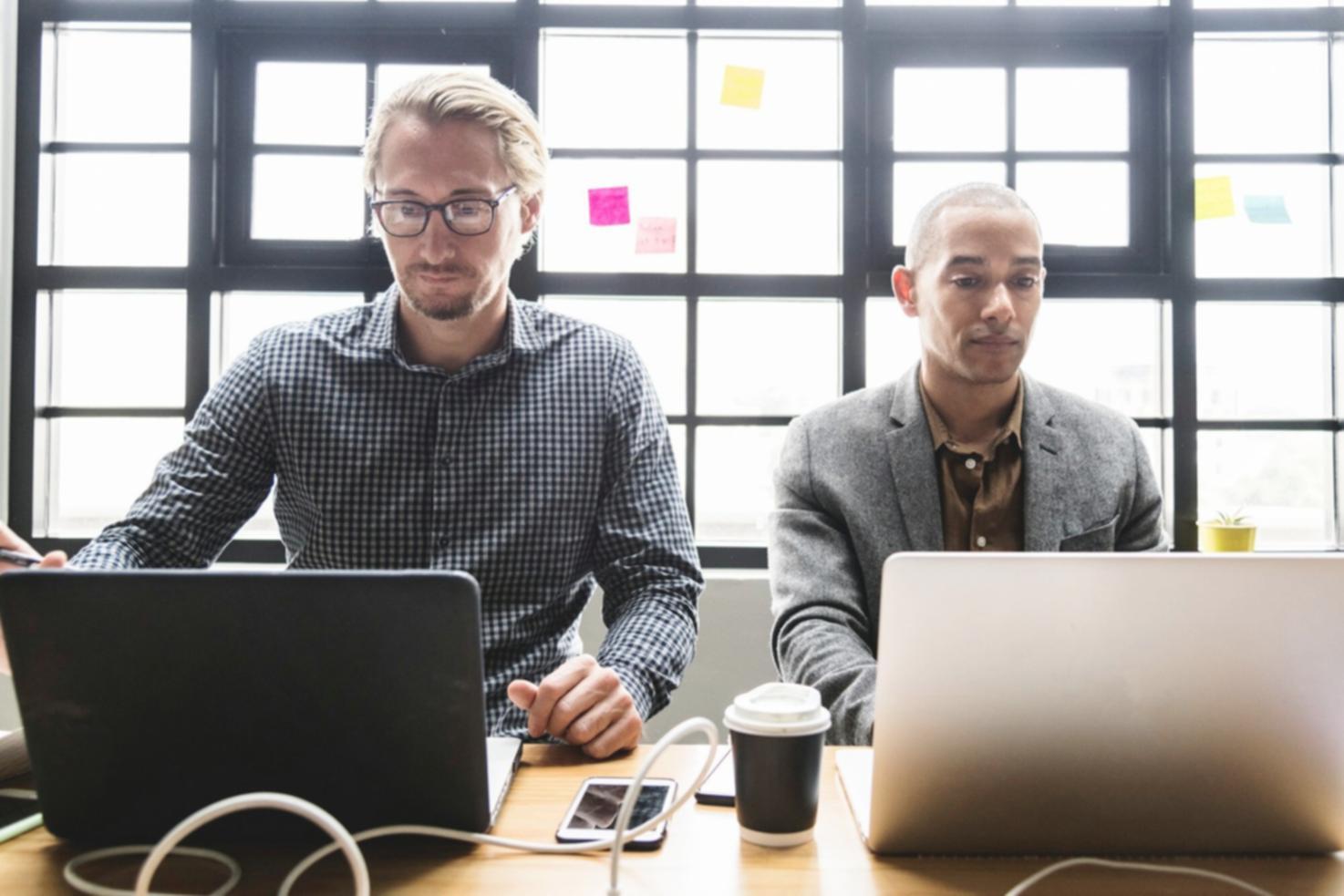 Modern computer setup with dual monitors displaying financial software interfaces
